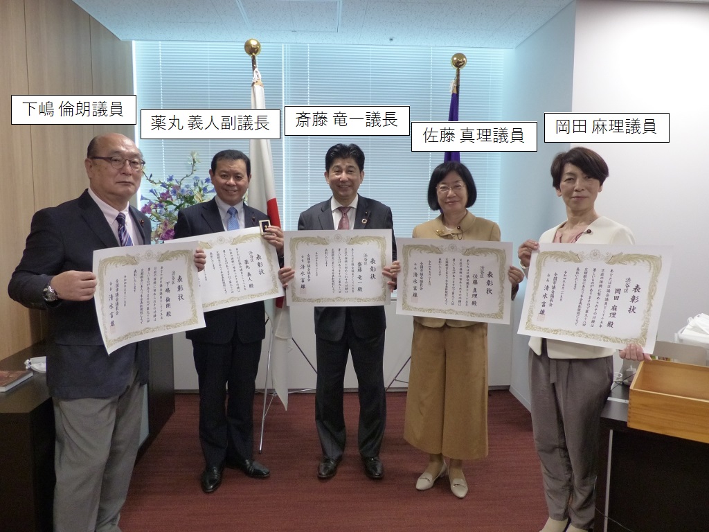 写真：表彰状を手にする、左からしもじま　みちお議員、やくまる　よしと副議長、さいとう　りゅういち議長、さとう　まり議員、おかだ　まり議員