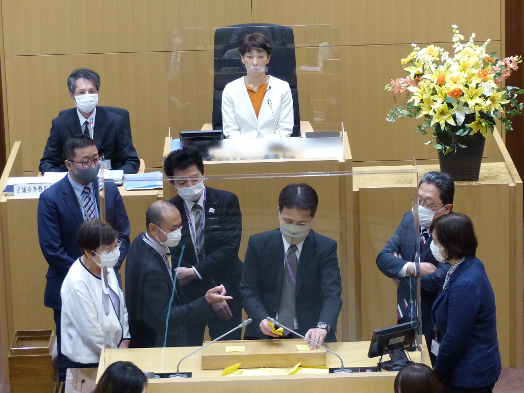 写真：議員立ち合いのもと、演壇で行われる開票の様子