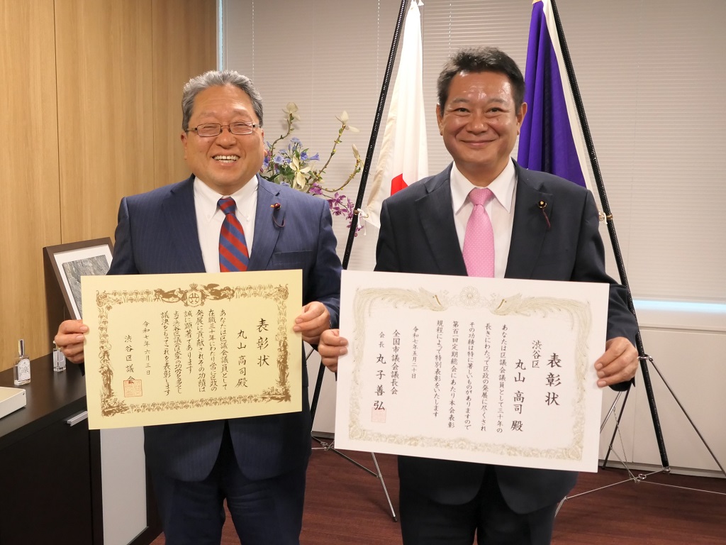 写真：左に全国市議会議長会からの30年以上表彰の賞状を持った丸山議員と右に渋谷区議会からの30年以上表彰の賞状を持ったひとつやなぎ議長が並んだ様子
