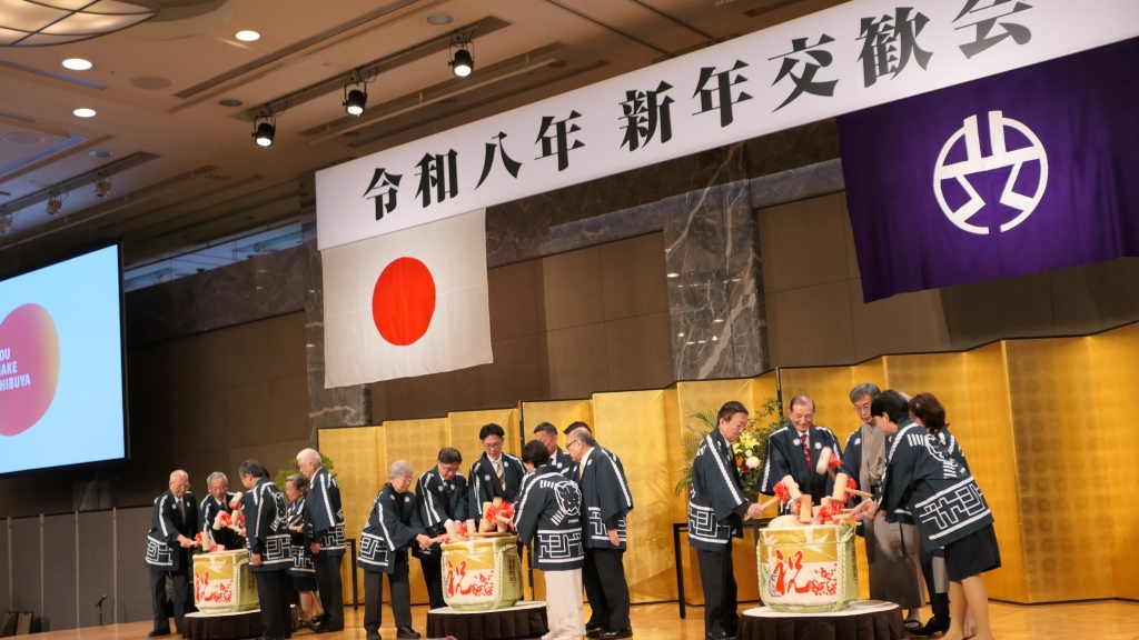 写真：議長、副議長を含めた青法被を着た人達による壇上3カ所での鏡開きの様子