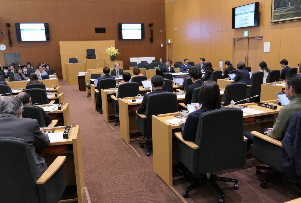 写真：議場の議席に着き、講師の話に聞き入る議員の様子