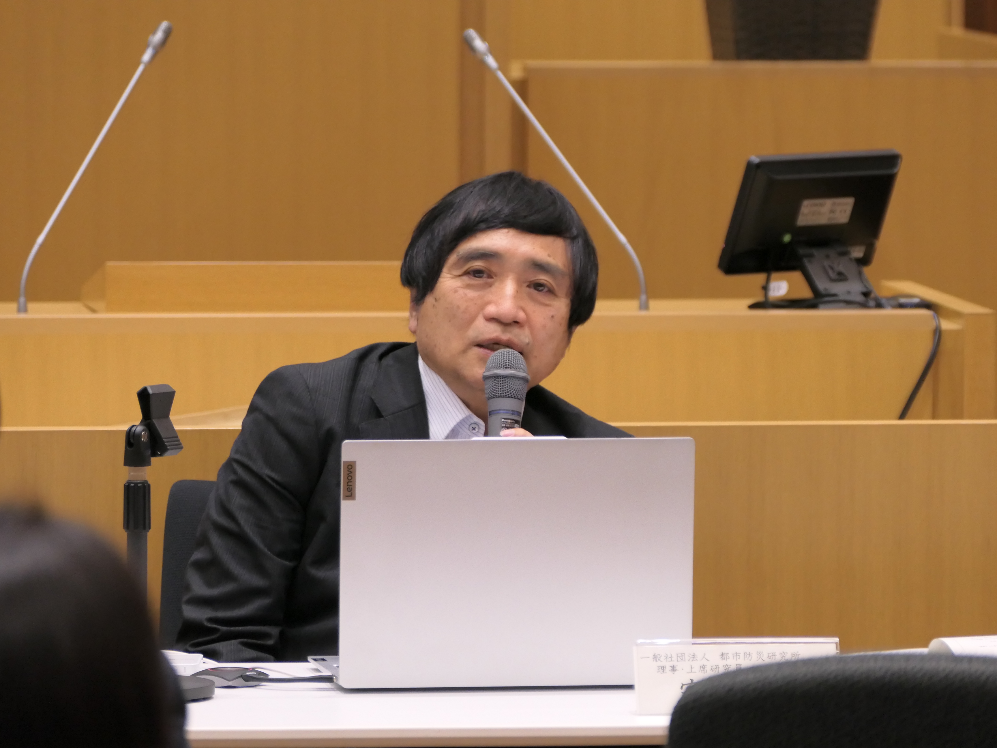 写真：議場で席に着いて話す　講師の　もり しげあき氏