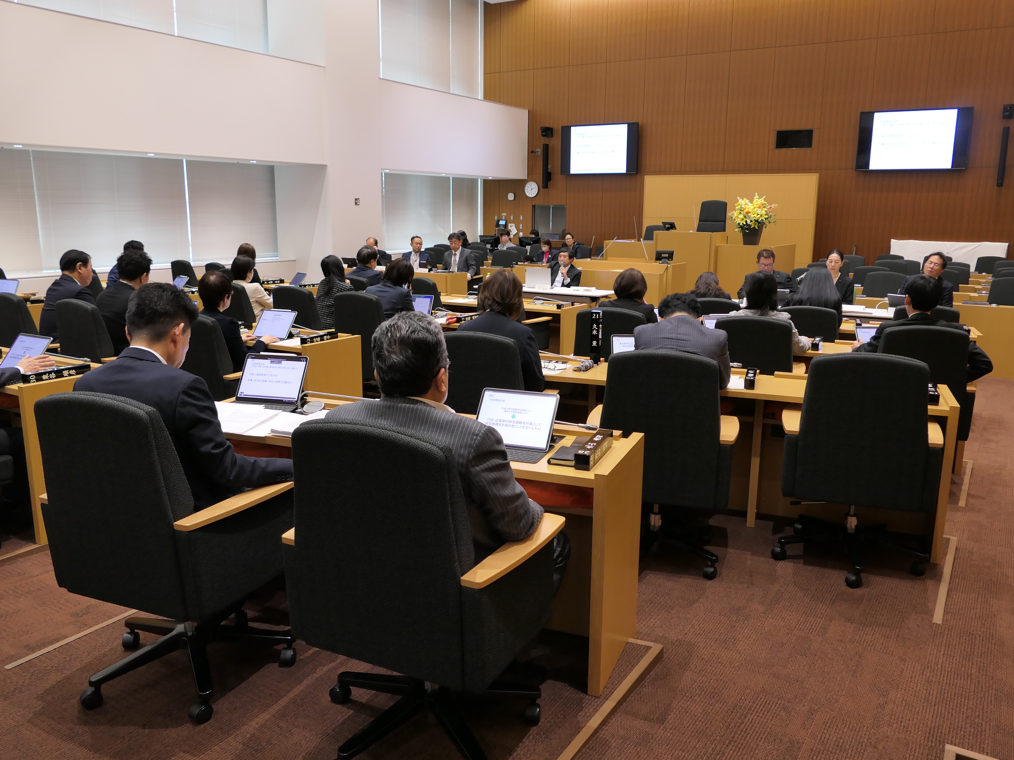 写真：議場の議席に着き、講師の話に聞き入る議員の様子